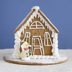 Пряничный новогодний домик с фигуркой снеговика. Вид спереди.